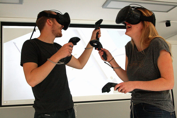 Irina Shiyanov und Max Bäßmann vom Team der VirtuaLounge erkunden mit Hilfe von Virtual-Reality-Brillen ein Raumschiff. (Wird bei Klick vergrößert)